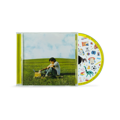 a cd case with a picture of a man sitting in the grass